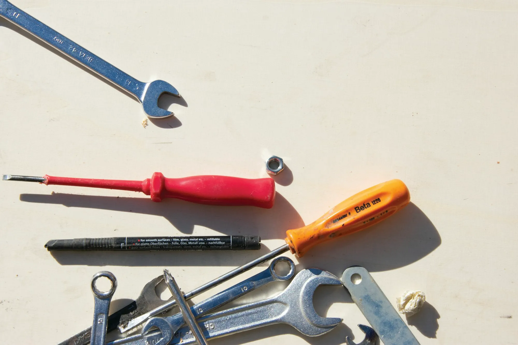 Wrench, screwdrivers and hand tools on a white surface