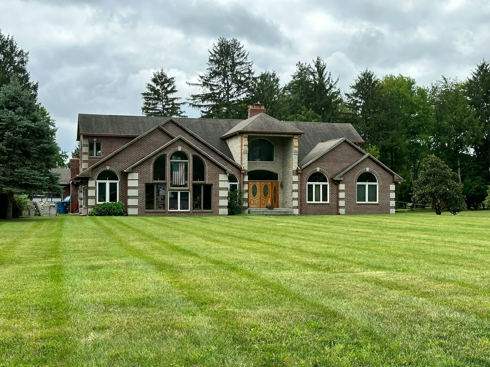 Large brick home with a striped green lawn